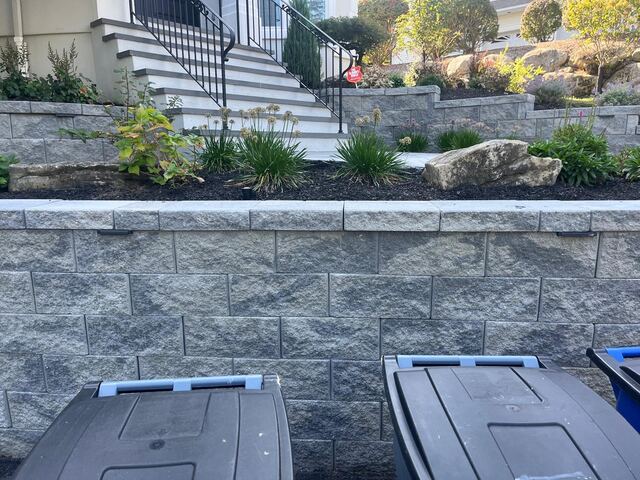 Block retaining wall with landscaped garden bed below front steps