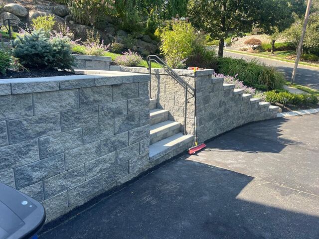 Curved retaining wall with integrated steps and metal handrail