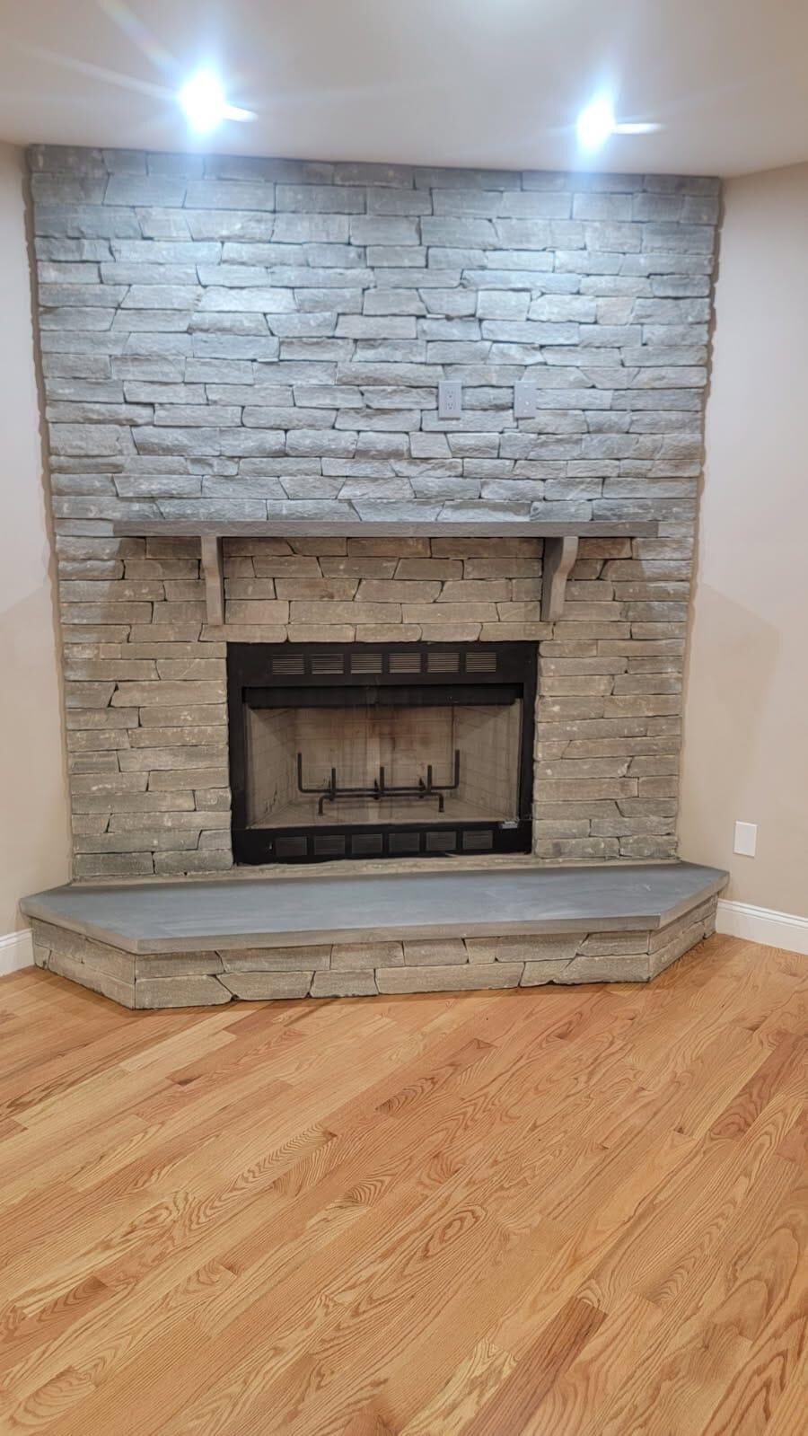 Floor-to-ceiling stacked stone interior fireplace with bluestone hearth and mantel